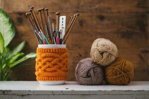 Jar holding needles with wool next to it